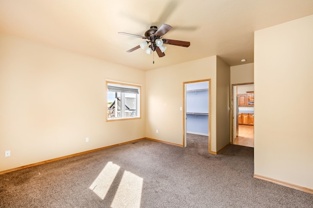 spare room with ceiling fan, carpet flooring, and baseboards