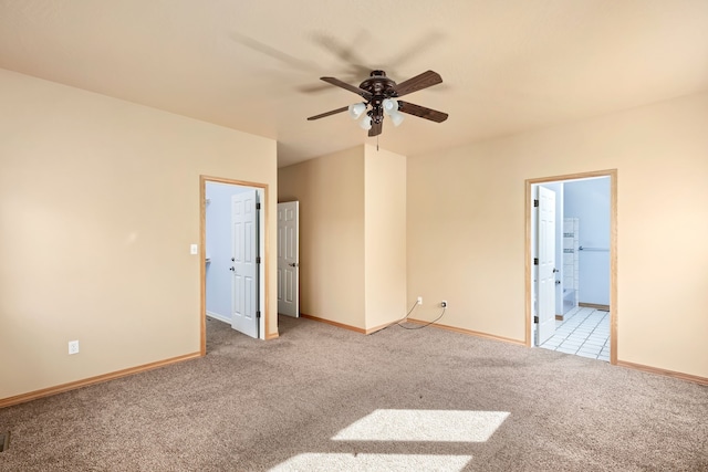 unfurnished bedroom with carpet floors, a ceiling fan, baseboards, and ensuite bathroom