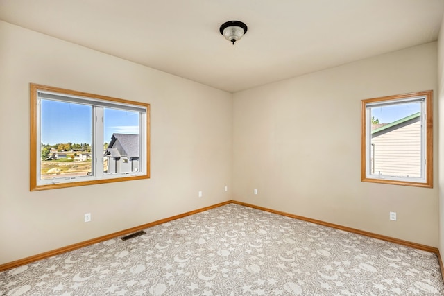 unfurnished room with baseboards, visible vents, and carpet flooring