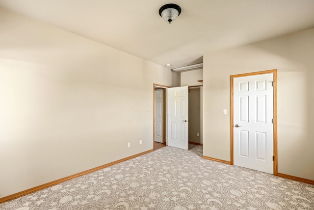 unfurnished bedroom featuring carpet and baseboards