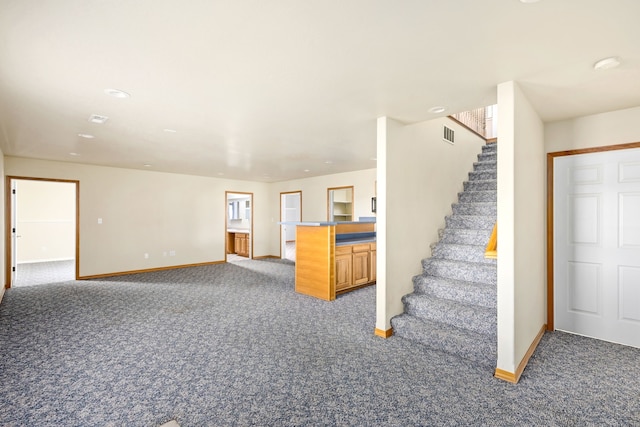 unfurnished living room with stairs, carpet flooring, visible vents, and baseboards