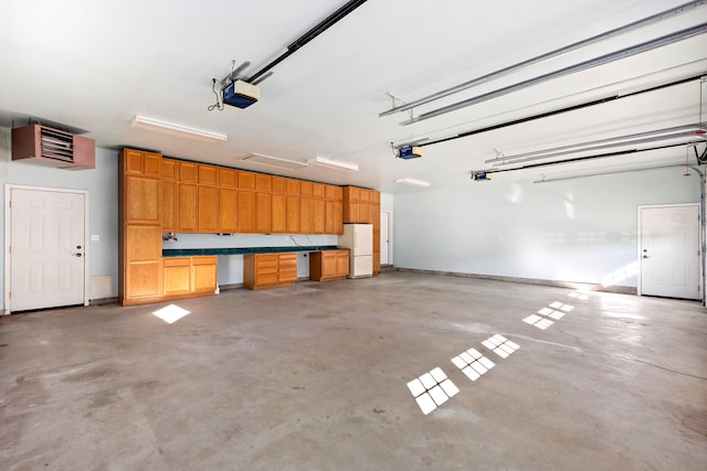 garage with a garage door opener and freestanding refrigerator