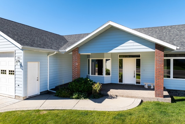 ranch-style house with a garage, a porch, and roof with shingles