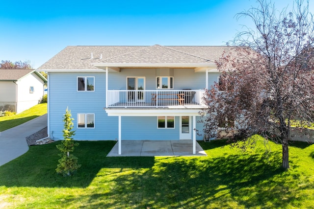 back of house featuring a yard, a shingled roof, and a patio