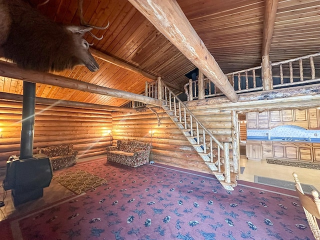 interior space with carpet, a wood stove, wood ceiling, and beam ceiling