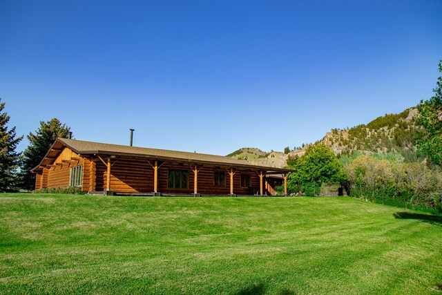 68 River Dr, Cascade, MT 59421 - rear view of property with log siding, a mountain view, and a lawn