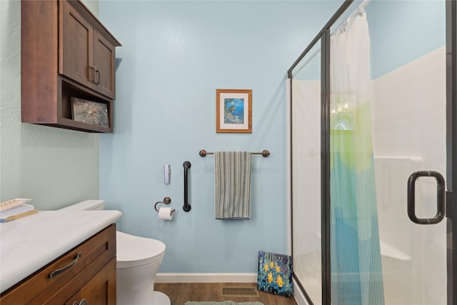 bathroom with a shower with door, wood-type flooring, vanity, and toilet