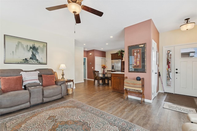 living room featuring dark wood-type flooring and ceiling fan