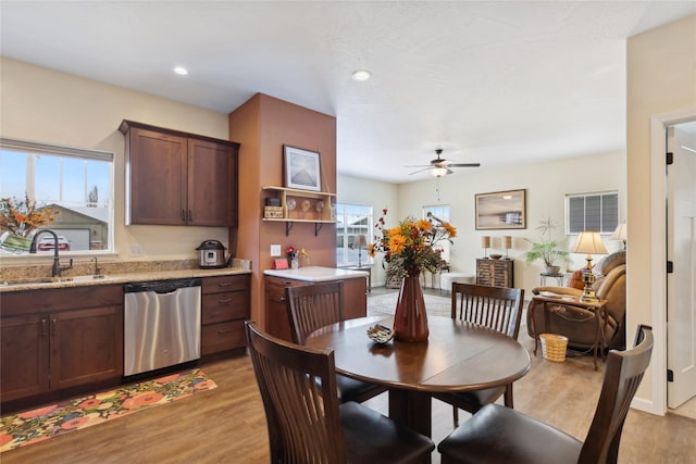 dining area featuring sink, ceiling fan, and light wood-type flooring