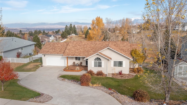 ranch-style house with a garage, a mountain view, and a front yard