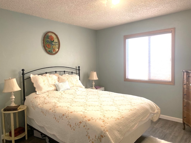 bedroom with hardwood / wood-style floors and a textured ceiling