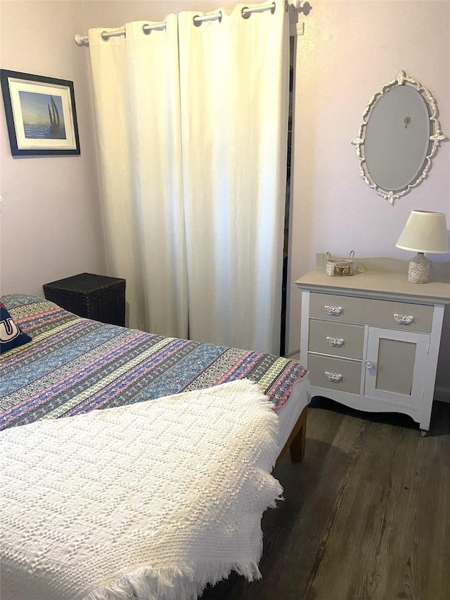 bedroom with dark hardwood / wood-style flooring