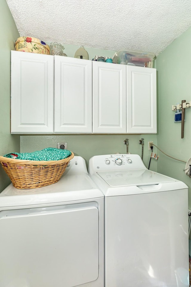 washroom featuring cabinets, separate washer and dryer, and a textured ceiling