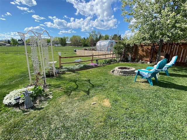 view of yard with an outdoor fire pit and an outdoor structure