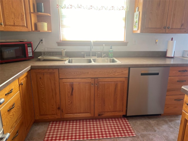 kitchen with sink, stainless steel dishwasher, and light tile patterned floors