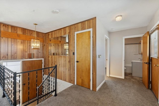 185 Veteran Dr, Columbia Falls, MT 59912 - corridor featuring an upstairs landing, baseboards, wooden walls, and carpet