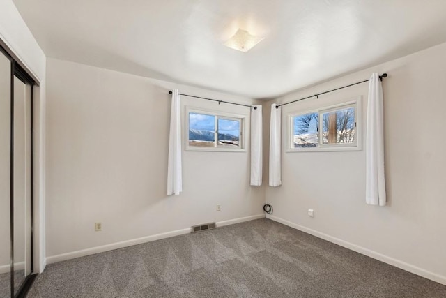 185 Veteran Dr, Columbia Falls, MT 59912 - unfurnished bedroom with a closet, baseboards, carpet, and visible vents