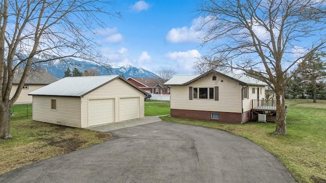 185 Veteran Dr, Columbia Falls, MT 59912 - view of property exterior with a mountain view, a detached garage, an outbuilding, a yard, and metal roof