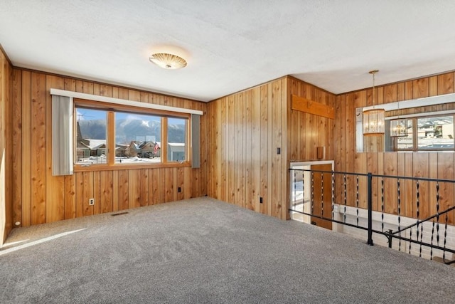 185 Veteran Dr, Columbia Falls, MT 59912 - carpeted spare room featuring a wealth of natural light, wooden walls, and a notable chandelier