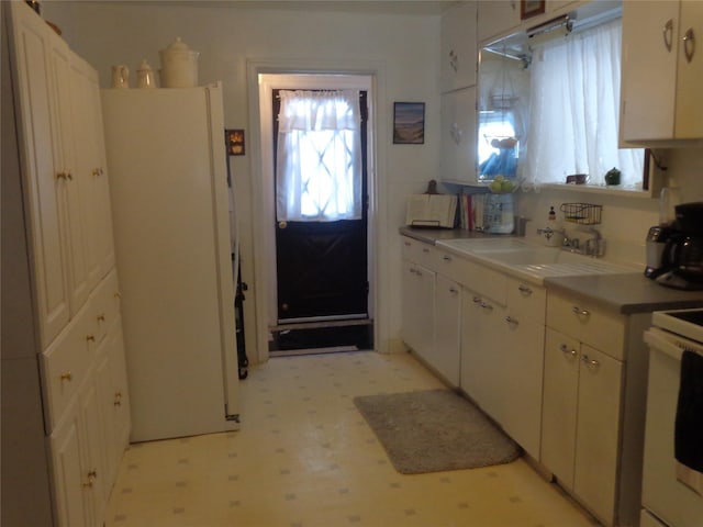 kitchen with white cabinetry, sink, and white appliances