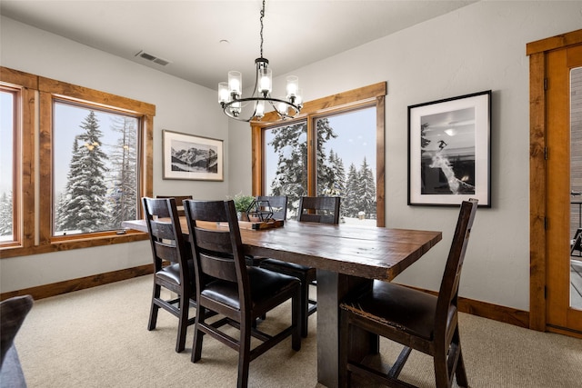 carpeted dining space featuring an inviting chandelier