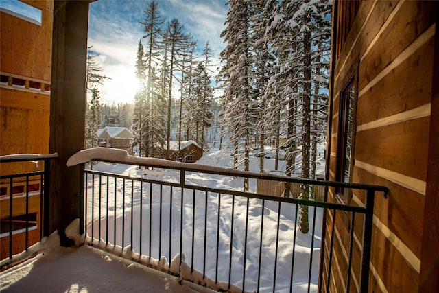 view of snow covered back of property