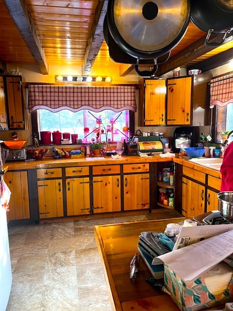 kitchen featuring sink, wooden ceiling, and beam ceiling