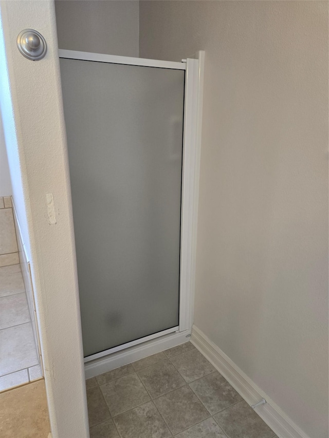 bathroom featuring an enclosed shower and tile patterned floors