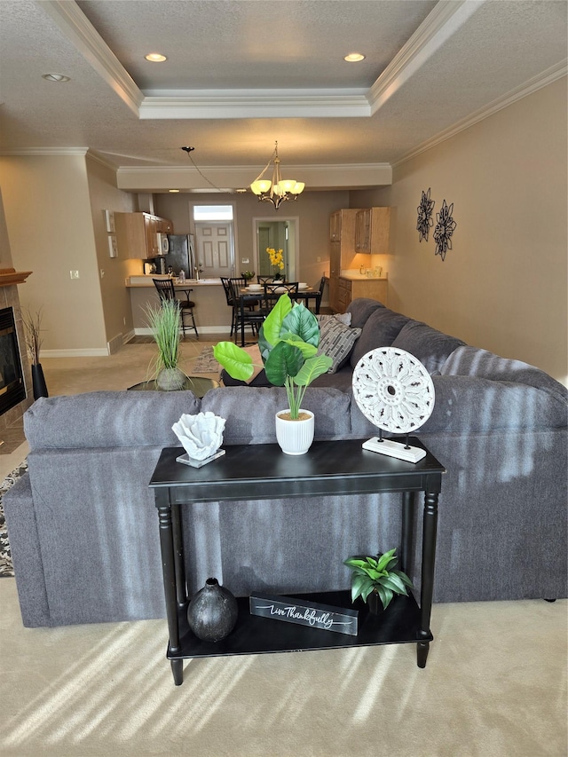 living room with crown molding, a fireplace, a raised ceiling, and carpet