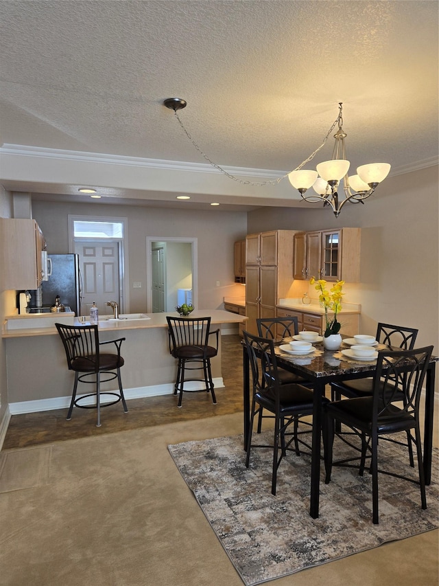 dining space with crown molding, sink, an inviting chandelier, and a textured ceiling