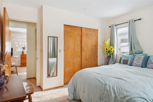 carpeted bedroom featuring multiple windows and a closet