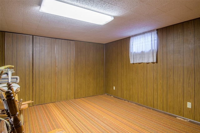 carpeted empty room with wooden walls