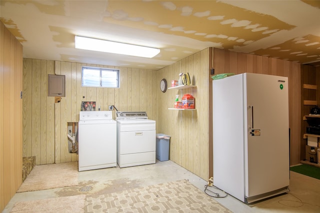 laundry area with washing machine and dryer and wood walls