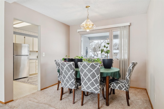 dining area with an inviting chandelier and light colored carpet