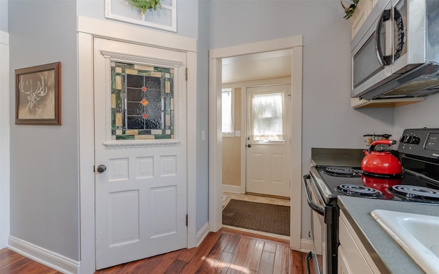 kitchen featuring electric stove, white cabinets, and hardwood / wood-style flooring