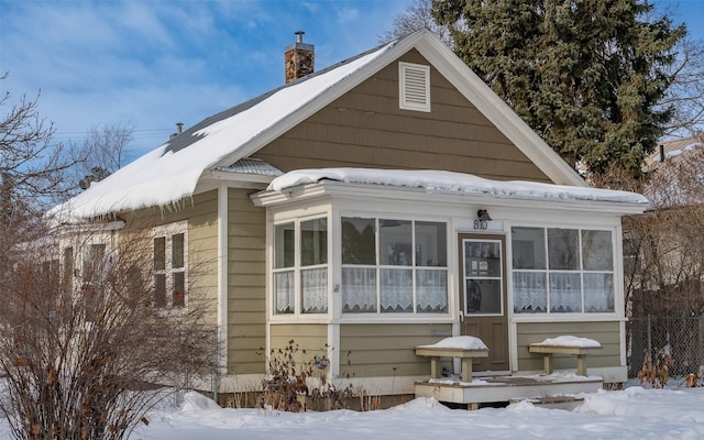 snow covered property with a sunroom