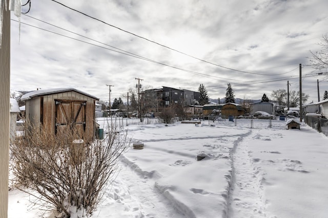 yard covered in snow featuring a shed