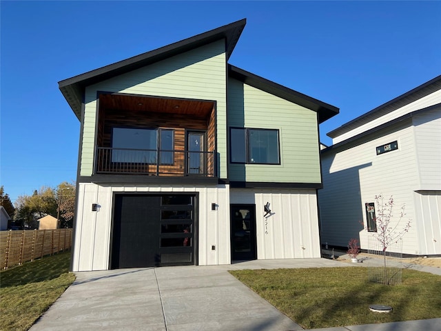 contemporary house with concrete driveway, board and batten siding, a front yard, fence, and a garage