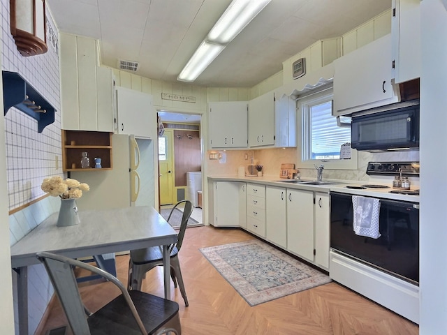 kitchen featuring sink, light parquet floors, white range with electric cooktop, white cabinetry, and tasteful backsplash