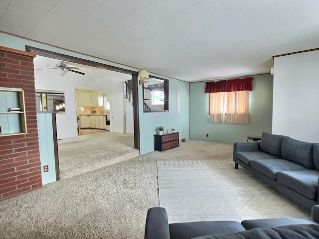 living room featuring ceiling fan, ornamental molding, and carpet flooring