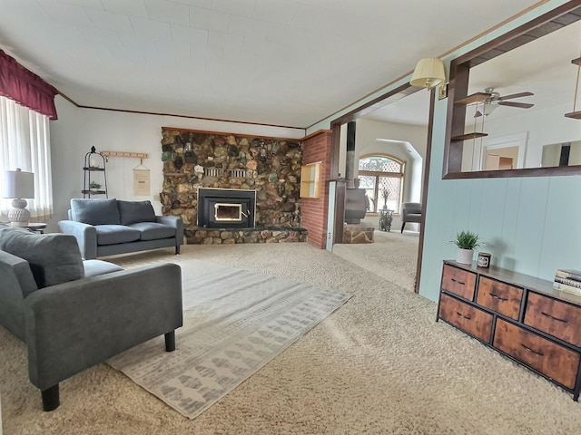 living room with a fireplace, ceiling fan, and carpet