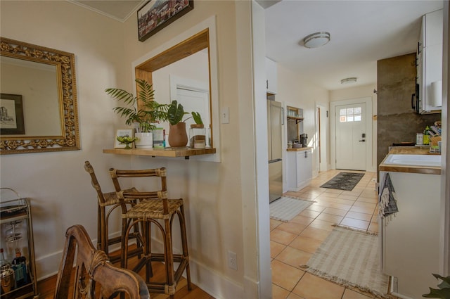 interior space with light tile patterned flooring and baseboards