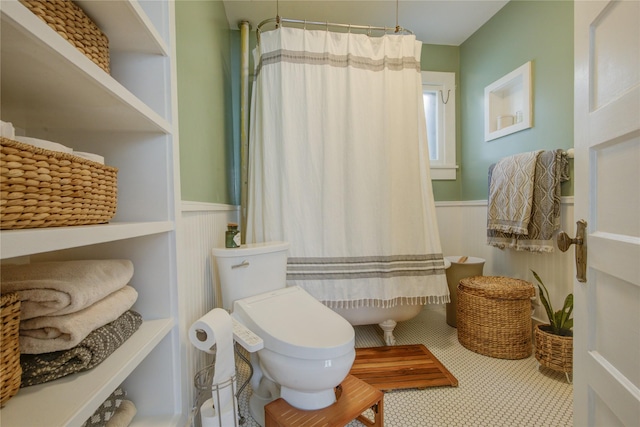 bathroom featuring a shower with curtain and a wainscoted wall