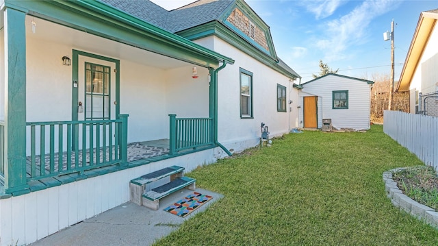 exterior space with an outdoor structure, covered porch, and fence