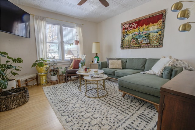 living area with an ornate ceiling, a ceiling fan, and light wood finished floors