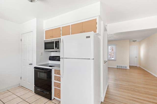 kitchen with electric range oven, light brown cabinets, light hardwood / wood-style floors, and white refrigerator