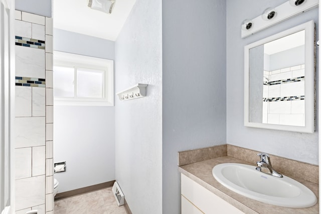 bathroom with a baseboard radiator, vanity, and toilet