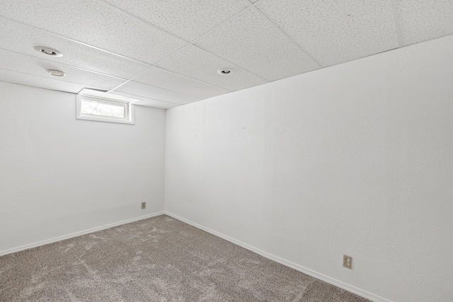 basement with carpet flooring and a paneled ceiling