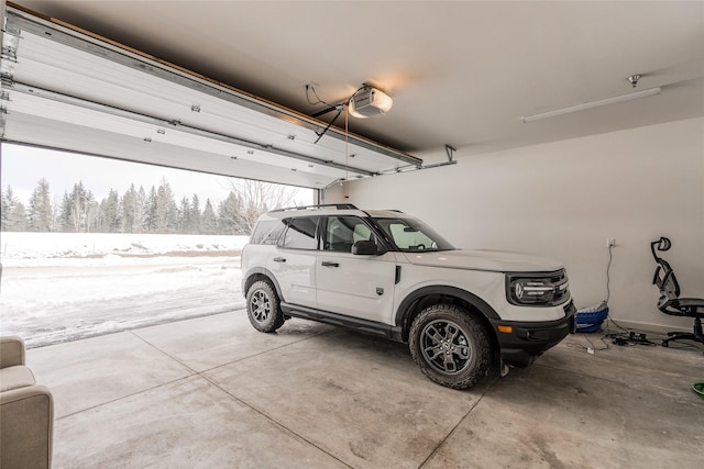 751 Lenna Joy Dr, Whitefish, MT 59937 - snow covered garage featuring a garage door opener