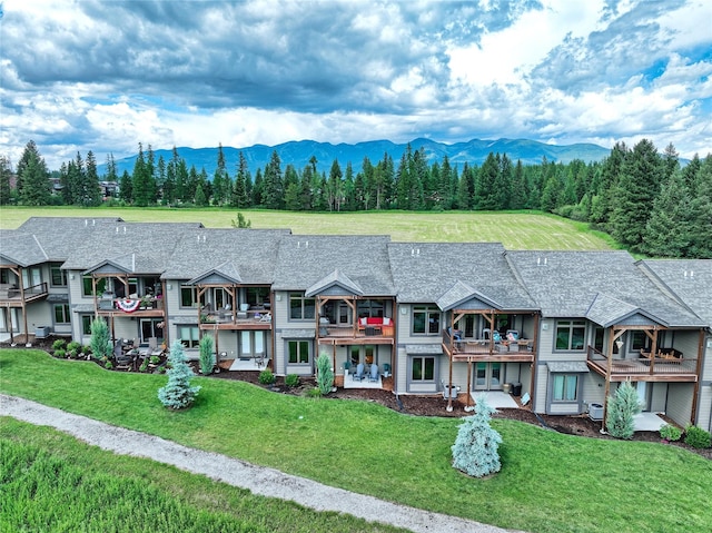 751 Lenna Joy Dr, Whitefish, MT 59937 - view of property featuring a mountain view, a balcony, a front yard, and a shingled roof